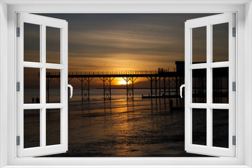 Fototapeta Naklejka Na Ścianę Okno 3D - A beautiful moody sunset with reflections in the water and sand be the Pier at Bognor Regis.