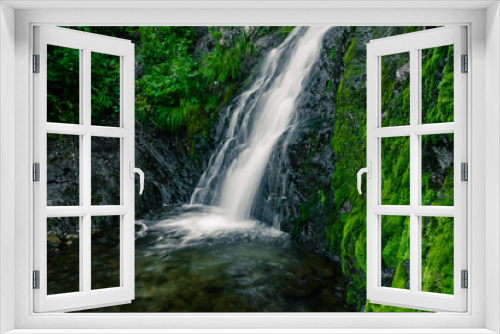 Fototapeta Naklejka Na Ścianę Okno 3D - Atmospheric view of waterfall on river in rainforest. Swift stream among rocks and green moss.