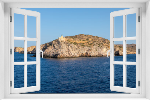 Fototapeta Naklejka Na Ścianę Okno 3D - View of the lighthouse on the peninsula, Chora , Ios Island, Greece.