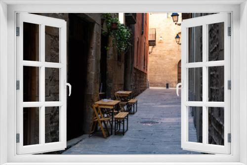 Fototapeta Naklejka Na Ścianę Okno 3D - Cafe with terrace on a narrow street with medieval historic houses in Barcelona