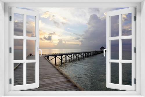 Fototapeta Naklejka Na Ścianę Okno 3D - Long wooden pier over the water, at sunset, Maldives 