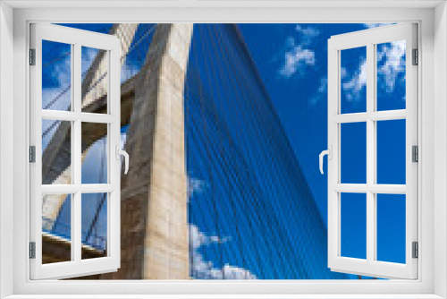 Fototapeta Naklejka Na Ścianę Okno 3D - Huge suspension bridge and dam over blue sky, vertical composition