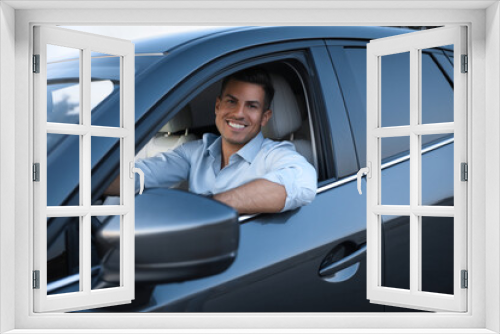 Handsome man in his modern car, view from outside