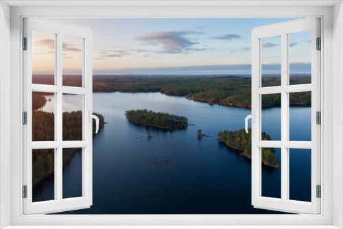 Fototapeta Naklejka Na Ścianę Okno 3D - Aerial view of of small islands on a blue lake Haukkajarvi in Helvetinjarvi National park. Blue lake, islands and green forests from above on a summer evening. 