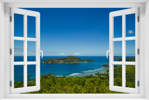 Fototapeta Naklejka Na Ścianę Okno 3D - Panoramic view of the densely overgrown green Seychelles washed by turquoise water, the horizon is buried in the sea.