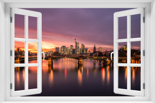 Fototapeta Naklejka Na Ścianę Okno 3D - The Main with the Frankfurt skyline in the evening, at sunset. Nice overview of the city and its surroundings. in a special shade