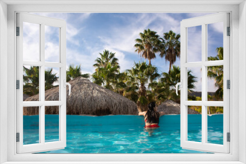 Fototapeta Naklejka Na Ścianę Okno 3D - Young woman in a swimming pool in a tropical place