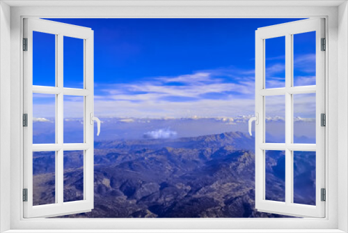 Fototapeta Naklejka Na Ścianę Okno 3D - View from the airplane window on a mountain landscape in Turkey on a sunny cloudless day. Beautiful natural panorama of the peaks against the background of the blue sky and armosphere - top view