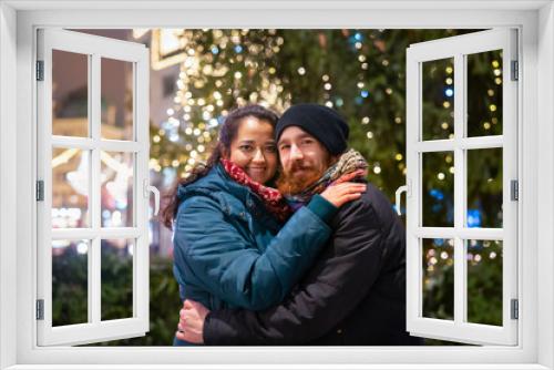 Happy young mulinational couple outdoor in a city center at Christmas