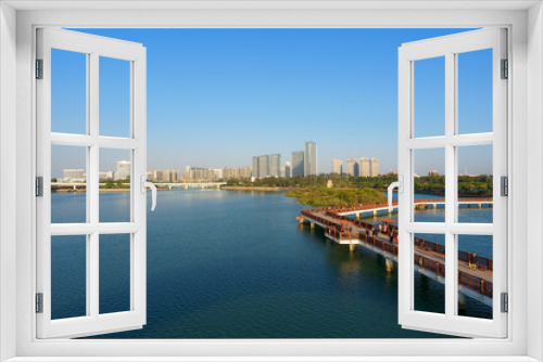 Fototapeta Naklejka Na Ścianę Okno 3D - Landscapes of Xiamen Wuyuanwan Natural Park and Wuyuan Bridge in distance with water foreground and Xiamen city skyline