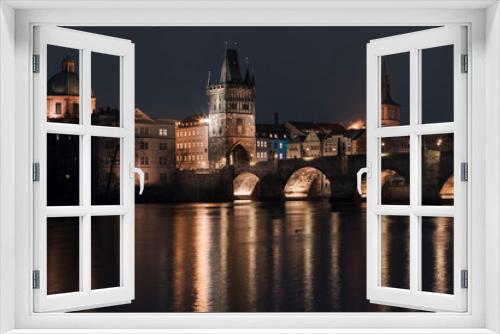 .Charles Bridge at night and light from street lights on the Vltava River in the center of Prague at night in the Czech Republic