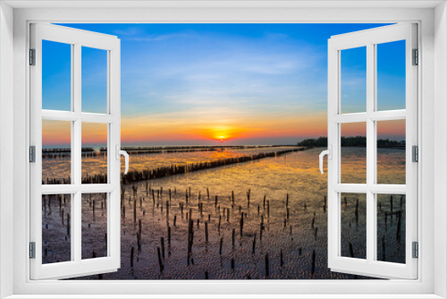 Fototapeta Naklejka Na Ścianę Okno 3D - The sunset at the sea due to the low tide that the wetlands are visible in the evening.