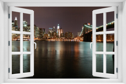 Fototapeta Naklejka Na Ścianę Okno 3D - Night view of the emblematic buildings and skyscrapers of Manhattan (New York).  Skyline. Hudson River. Brooklyn Bridge
