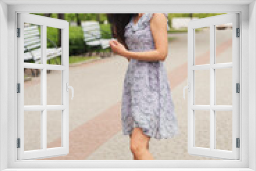 Young elegant girl posing at city street. Pretty beautiful business woman in elegant dress against city background.