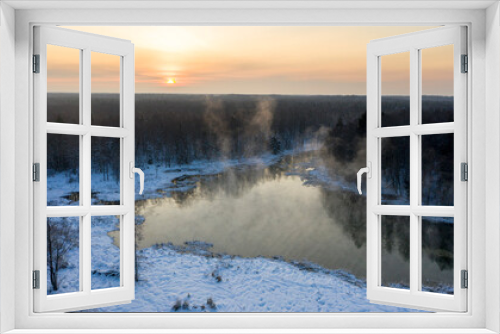Fototapeta Naklejka Na Ścianę Okno 3D - Aerial drone image of the natural groundwater spring scenery with the heavily steaming water during the freezing cold winter sunset