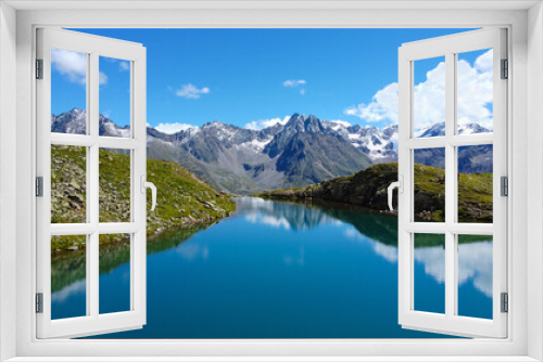 Fototapeta Naklejka Na Ścianę Okno 3D - Perler See Bergsee in den Alpen, Berge mit See und blaues Wasser in Felsen mit Grün und Schnee beim Wandern für eine Auszeit und Erholung bei blauem Himmel