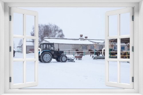 Fototapeta Naklejka Na Ścianę Okno 3D - Tractor removes snow on the farm
