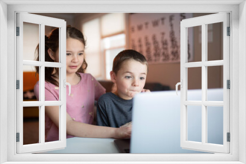 boy and girl looking at a laptop with a worried and confused look