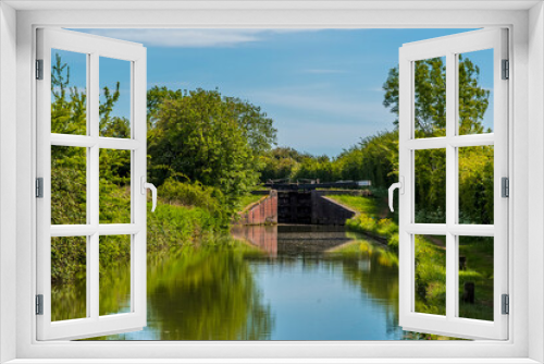 Fototapeta Naklejka Na Ścianę Okno 3D - A view up the Oxford canal towards a lock gate at the village of Napton, Warwickshire in summertime