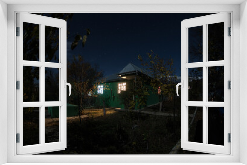 Fototapeta Naklejka Na Ścianę Okno 3D - Mountain night landscape of building at forest at night with moon or vintage country house at night with clouds and stars. Summer night.