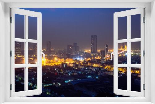 Fototapeta Naklejka Na Ścianę Okno 3D - The high angle background of the city view with the secret light of the evening, blurring of night lights, showing the distribution of condominiums, dense homes in the capital community