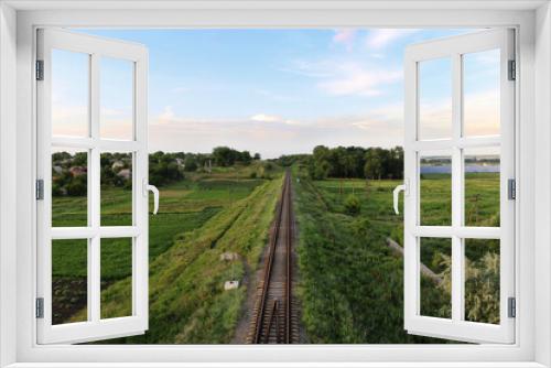 Fototapeta Naklejka Na Ścianę Okno 3D - railway track through the village solar power plant