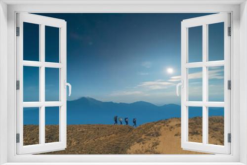 Fototapeta Naklejka Na Ścianę Okno 3D - The four hikers walking on picturesque night mountains background