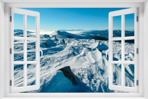 Fototapeta Naklejka Na Ścianę Okno 3D - A close up on the snow capped Alps in the region of Speikkogel in Austrian Alps. The whole are is covered with snow. Many mountain chains in the back. Thick fog in the valley. Winter outdoor activity.