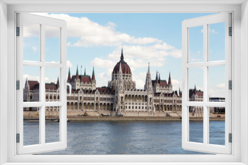 The magnificent building of the Hungarian Parliament on the Danube River embankment. Summer sunny day. Budapest, Hungary.