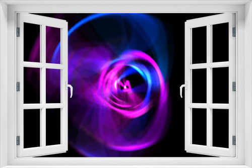 Fototapeta Naklejka Na Ścianę Okno 3D - Spinning rays of light isolated on black background. Graphic 2D illustration of glowing colorful light particles in circular motion.