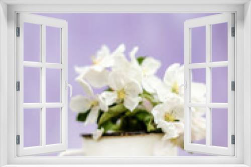 Fototapeta Naklejka Na Ścianę Okno 3D - Flowers of apple trees on branch, collected in bouquet. Still life of an old iron mug and flowering branches of fruit tree on a purple blurred background