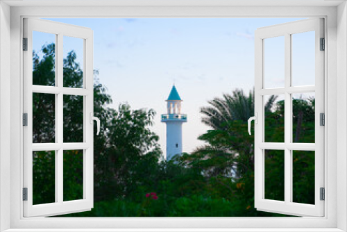 Background image of mosque minaret visible between the trees in Qatar