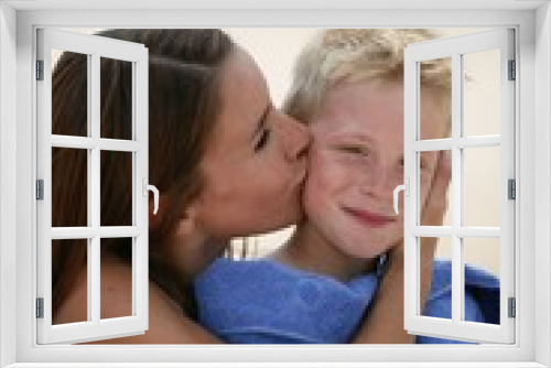 Woman kissing her son on a beach