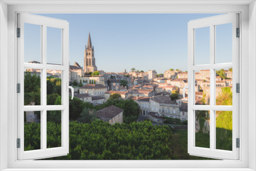 Fototapeta Naklejka Na Ścianę Okno 3D - A vineyard view of the Monolithic Church and village of Saint-Emilion in Bordeaux wine country on a sunny summer day.