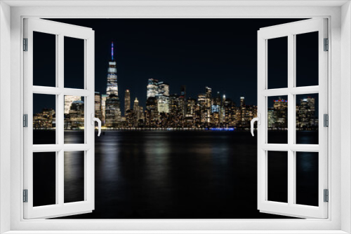 Fototapeta Naklejka Na Ścianę Okno 3D - New York City Skyline at Night with reflection of the skyline in the Hudson river