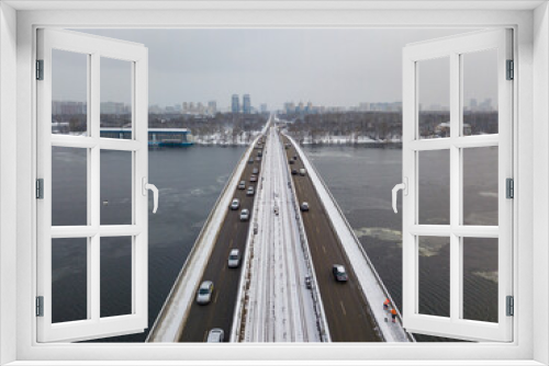 Fototapeta Naklejka Na Ścianę Okno 3D - Snow-covered metro bridge in Kiev. Cloudy winter morning. Aerial drone view.