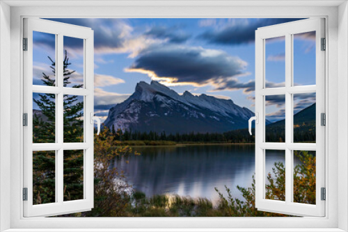 Fototapeta Naklejka Na Ścianę Okno 3D - Moonrise at Vermilion Lakes in summer night. Banff National Park, Canadian Rockies, Alberta, Canada. Bright full moon over Mount Rundle and light up the night with golden reflection on lake surface.