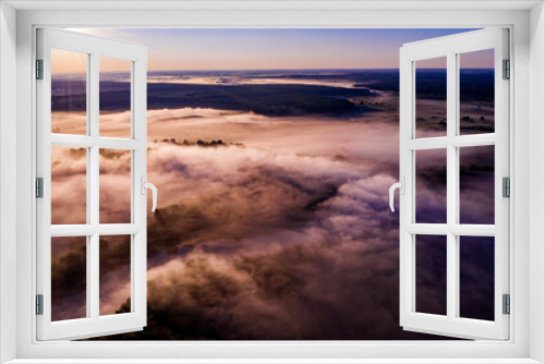 Fototapeta Naklejka Na Ścianę Okno 3D - Aerial  view of a beautiful summer  landscape with a fog while dawn.  Photo from drone of a foggy landscape in spring. Top view to land while sunrise. Early morning in nature, misty  weather.