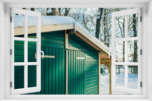 Fototapeta Naklejka Na Ścianę Okno 3D - grüne Holzhütte im Winter bei Schnee im Wald