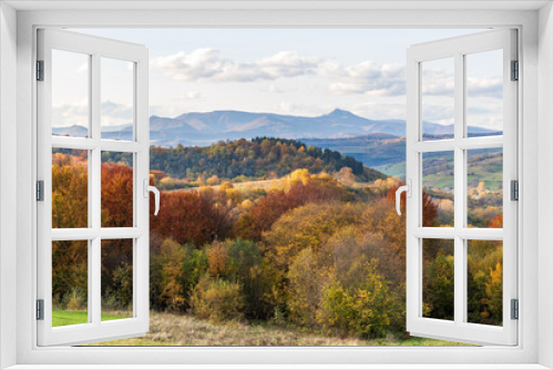 Fototapeta Naklejka Na Ścianę Okno 3D - Autumn mountain landscape - yellowed and reddened autumn trees combined with green needles and blue skies. Colorful autumn landscape scene in the Ukrainian Carpathians. Panoramic view.