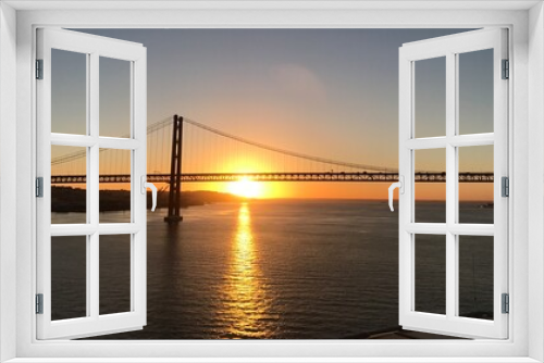 Fototapeta Naklejka Na Ścianę Okno 3D - Portugal Lissabon Brücke des 25. April Hängebrücke Metall über dem Fluss Tejo von einem Kreuzfahrtschiff aus am Morgen bei Sonnenaufgang am Horizont