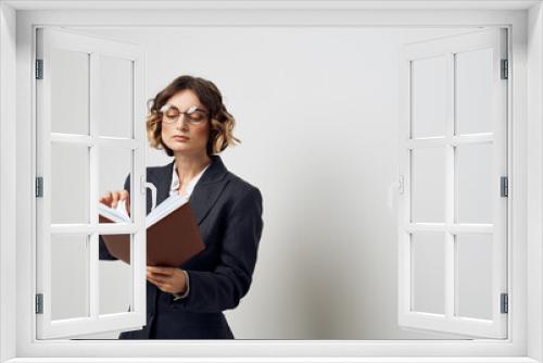 A woman in a classic suit with a book in her hand glasses on her face work cabinet model