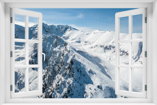 Fototapeta Naklejka Na Ścianę Okno 3D - Panoramic view of snowy landscape with virgin snow untouched, beautiful snow-capped mountains against the blue sky. A dangerous place for skiing and snowboarding.