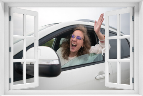 Woman driving very angry sticking her arm out the window in a traffic jam.