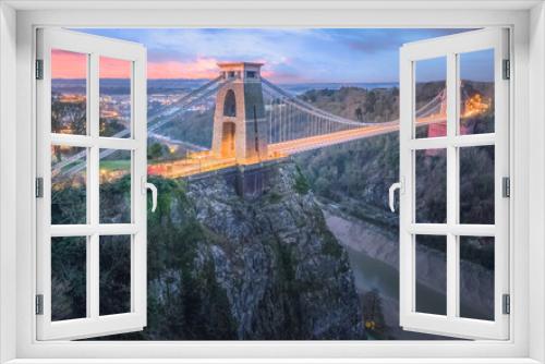 Fototapeta Naklejka Na Ścianę Okno 3D - Cityscape view of Bristol, England, UK and the Clifton Suspension Bridge above the Avon Gorge and River Avon at sunset or sunrise from St Vincent's Rocks.