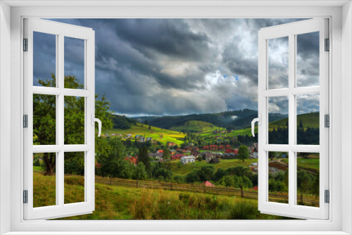 Fototapeta Naklejka Na Ścianę Okno 3D - Village in the mountains, against the backdrop of green slopes and forests