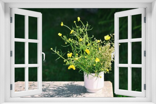Fototapeta Naklejka Na Ścianę Okno 3D - Wildflowers and green grass in a white cup on a wooden chair in a spring garden. Rural landscape. Spring season. Copy space