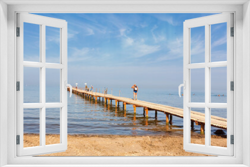 Fototapeta Naklejka Na Ścianę Okno 3D - People on the pier are enjoying their summer vacations and the sea view.