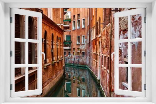 Fototapeta Naklejka Na Ścianę Okno 3D - Narrow canal between rows of old buildings in Venice