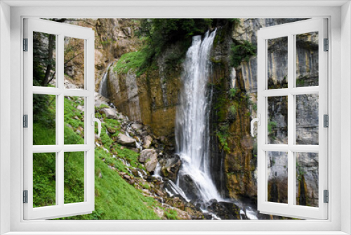 Fototapeta Naklejka Na Ścianę Okno 3D - Beautiful waterfall in switzerland rushing down a cliff and bursting onto a steep rocky mountainside
